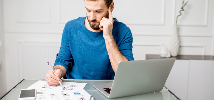 Successful brands build a positive user experience into their branding. That means creating an experience that aligns with the brand’s identity, whether that’s the product and service they sell, the way they do business, or the way they interact with their customers. a man working on his sketches in front of a laptop